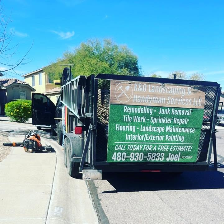 K&O Landscaping and Handyman Services trailer on the job, signage listing services and phone number