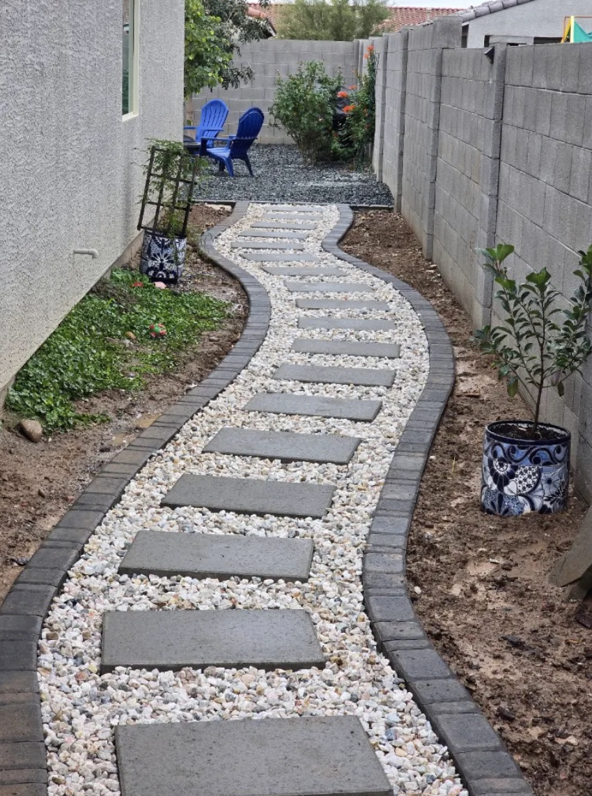 Curving stepping-stone walkway set in white rock with paver edging
